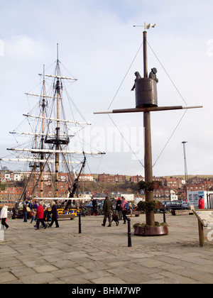 Statua a Whitby del "barrel" Crow's Nest inventato dal locale mariner William Scoresby e la replica della nave a vela Grand Turk Foto Stock