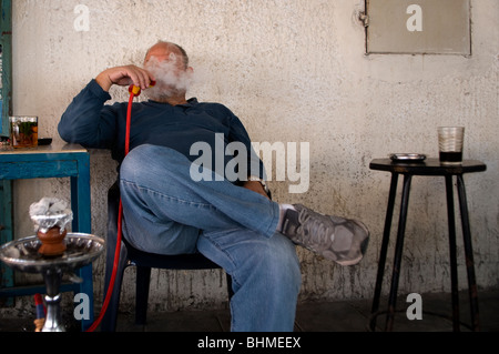 Un arabo israeliano uomo di fumare narghilè tubo in Ajami un misto arabo quartiere ebraico di Jaffa a sud di Tel Aviv, Israele Foto Stock