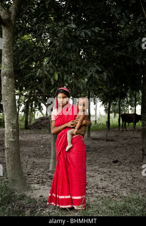 Una ragazza e il suo bambino in una fattoria fuori Dhaka, Bangladesh. Foto Stock