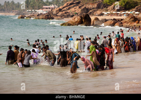 India Kerala, Kovalam, Samudra Beach, turisti indiano di balneazione in mare completamente vestito Foto Stock