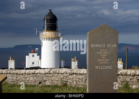 Il faro di Dunnett testa sulla costa nord della Scozia con l'isola di stroma in background. Foto Stock