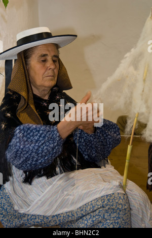 Donna anziana in costume tradizionale la filatura della lana, Ibiza, Spagna Foto Stock