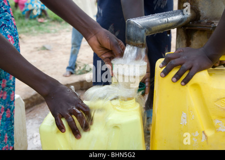 I bambini di recuperare acqua fresca da bere in corrispondenza di un foro di trivellazione nel quartiere Amuria, teso Regione, Uganda. Foto Stock