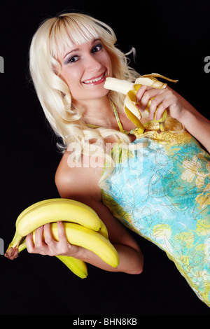 Giovane donna con grappolo di banane Foto Stock