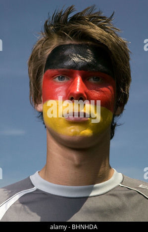 Un tedesco patriottico sostenitore di calcio con la bandiera tedesca dipinto sul suo viso Foto Stock