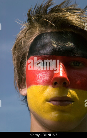 Un tedesco patriottico sostenitore di calcio con la bandiera tedesca dipinto sul suo viso Foto Stock