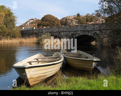 Brynrefail, Gwynedd, il Galles del Nord, Regno Unito, Europa. Barche ormeggiate dai Afon Rhythallt fiume vicino a un antico ponte in pietra in Snowdonia Foto Stock