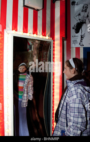 Ragazza giovane cerca in specchio distorcente   Ci credi o no di Ripley! Odditorium, Blackpool, Regno Unito Foto Stock