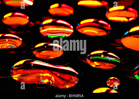 Extreme closeup di gocce d'acqua che riflette i colori Foto Stock