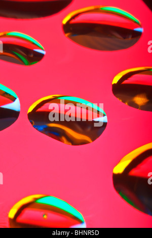 Extreme closeup di gocce d'acqua che riflette i colori Foto Stock