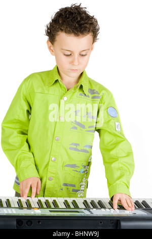 Carino piccolo ragazzo giocando synth o piano, isolati su sfondo bianco Foto Stock