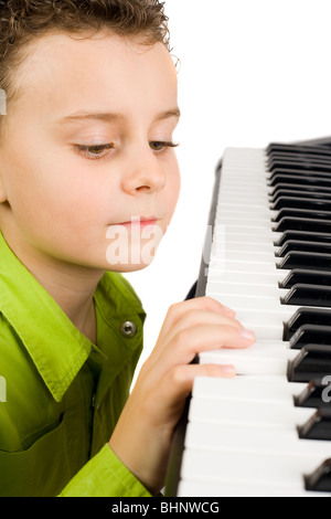 Carino piccolo ragazzo giocando synth o piano, isolati su sfondo bianco Foto Stock