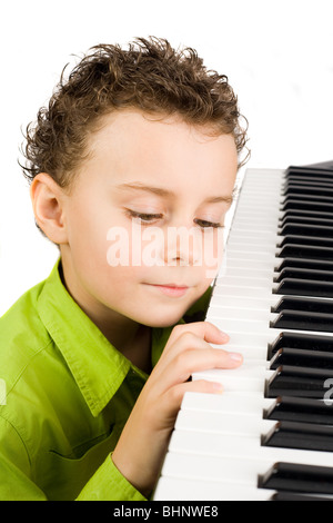 Carino piccolo ragazzo giocando synth o piano, isolati su sfondo bianco Foto Stock