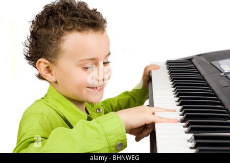 Carino piccolo ragazzo giocando synth o piano, isolati su sfondo bianco Foto Stock