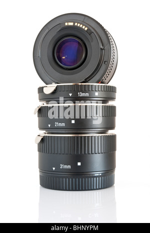 La lente della fotocamera e un set di estensione del tubo utilizzati per la fotografia macro isolati su sfondo bianco Foto Stock