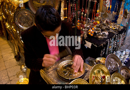 L'uomo pounding lastre metalliche nelle strade della zona Medina di Tunisi Tunisia del Nord Africa Foto Stock