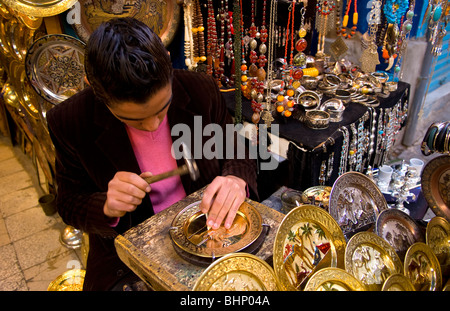 L'uomo pounding lastre metalliche nelle strade della zona Medina di Tunisi Tunisia del Nord Africa Foto Stock