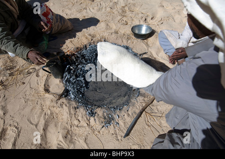 Bedouin uomini preparare il Libeh, una versione beduino di semplice azzimo pane piatto tipico della vita nel deserto Foto Stock