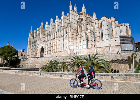 Matura in sella ad una bicicletta in tandem. Cattedrale. Palma de Mallorca. Spagna Foto Stock