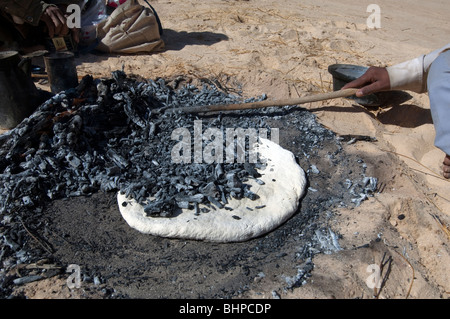 Bedouin uomini preparare il Libeh, una versione beduino di semplice azzimo pane piatto tipico della vita nel deserto Foto Stock