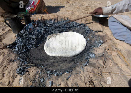 Bedouin uomini preparare il Libeh, una versione beduino di semplice azzimo pane piatto tipico della vita nel deserto Foto Stock