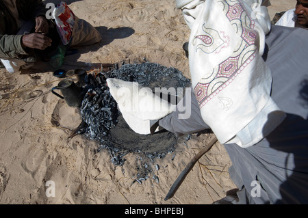 Bedouin uomini preparare il Libeh, una versione beduino di semplice azzimo pane piatto tipico della vita nel deserto Foto Stock