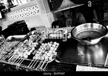 Old Lady vendita di pesce BBQ e polpette di carne, la vita di strada , Bangkok , Thailandia Foto Stock