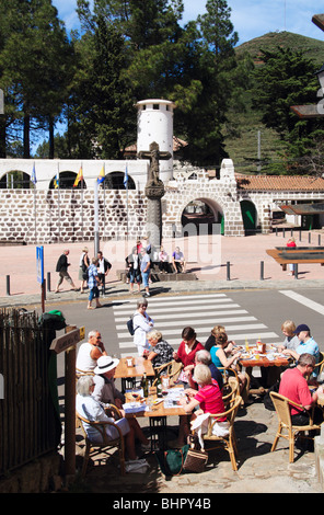 I turisti di mangiare al ristorante sul ciglio della strada a Cruz de Tejeda (1500m) su Gran Canaria con il Parador hotel in background Foto Stock