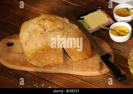 Pane appena sfornato pagnotta di pane marrone sul tavolo per la colazione Foto Stock