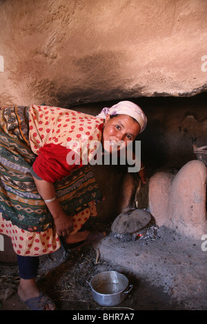 Una donna berbera cuochi utilizzando un forno tradizionale in Atlas Mountains, Marocco, Africa del nord Foto Stock