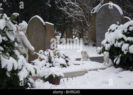 St Leonards cimitero con lapidi coperte di neve, Heston West London, Regno Unito Foto Stock