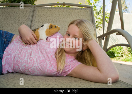 Ritratto 10-11 anno vecchia ragazza rilassa rilassarsi giocando con i suoi graziosi animali cavia al di fuori di swing. Stati Uniti signor © Myrleen Pearson Foto Stock