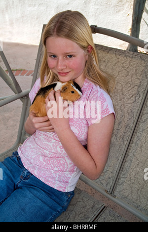 Ritratto 10-11 anno vecchia ragazza rilassa rilassarsi giocando con cute di cavia swing al di fuori di Stati Uniti Tween tween giovane popolo signor © Myrleen Pearson Foto Stock