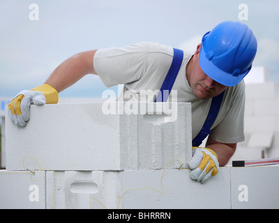 Mason allineando aerato autoclavato blocchi di cemento costruito di muro di casa Foto Stock
