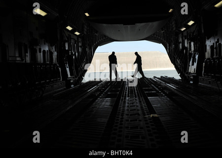 C-17A Globemaster III loadmasters andare attraverso controlli prefight sulla rampa. Foto Stock