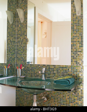 Close-up di grande specchio sopra bacino di vetro nel bagno moderno con  verde e oro metallico piastrelle a mosaico Foto stock - Alamy