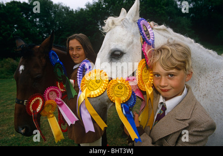 Due giovani ragazze stand con i loro amati a rosetta pony vincente in una gymkhana a Cheltenham, Gloucestershire. Foto Stock