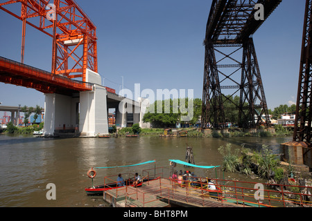 Piccole imbarcazioni che agiscono come traghetto per le popolazioni locali attraverso il fiume Riachuelo sotto al più presto per essere ricondizionati vecchio puente transbordador Foto Stock