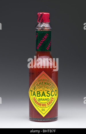 Bottiglia di salsa Tabasco calda Mcilhenny Habanero su sfondo grigio graduato Foto Stock