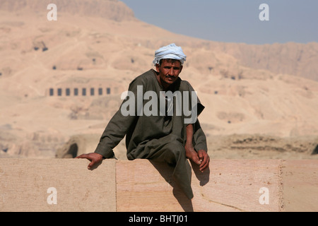 Uomo egiziano nel tradizionale djellaba prendendo una siesta al Ramesseum vicino a Luxor, Egitto Foto Stock