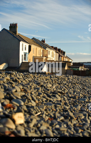 Una fila di case a schiera supporto su per la spiaggia di Borth villaggio su Cardigan Bay, Ceredigion, Wales UK Foto Stock