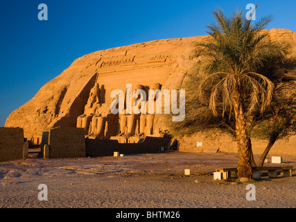 Statue intagliate di Ramses II a guardia del grande tempio di Abu Simbel a sunrise in Egitto. Foto Stock