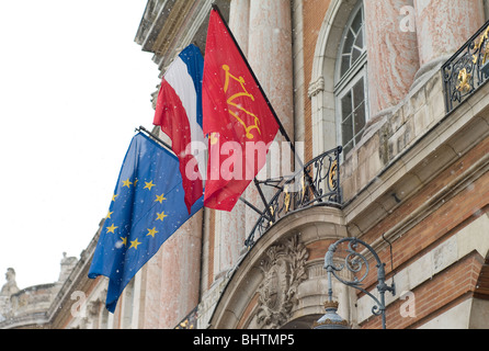 Europeo, Francese Tricolore e bandiere Occitane al di fuori il Capitole edificio, a Toulouse, la capitale regionale della Occitanie, Francia Foto Stock