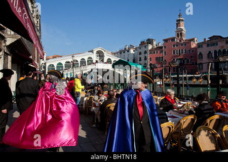 Camerieri vestiti in costume presso un ristorante esterno dal Ponte di Rialto durante il carnevale annuale, Venezia, Italia