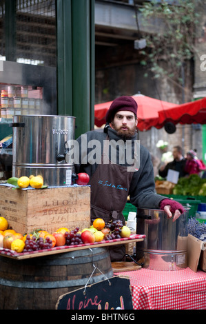 Commerciante di mercato la vendita di vino brulé, Borough Market, Londra Foto Stock