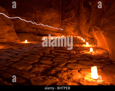 Il Al-Siq Canyon che conduce al Tesoro illuminato da candele per Petra di notte a Wadi Musa, Giordania. Foto Stock