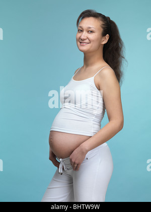 Sorridente giovane donna incinta. Settimo mese di gravidanza. Foto Stock