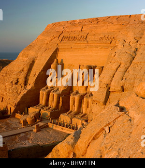 Statue intagliate di Ramses II a guardia del grande tempio di Abu Simbel a sunrise in Egitto. Foto Stock