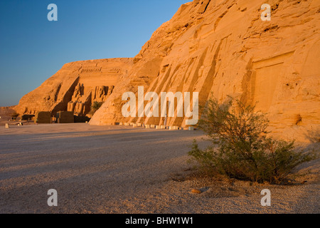 Statue intagliate di Ramses II a guardia del grande tempio di Abu Simbel a sunrise in Egitto. Foto Stock