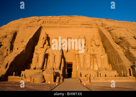 Statue intagliate di Ramses II a guardia del grande tempio di Abu Simbel a sunrise in Egitto. Foto Stock